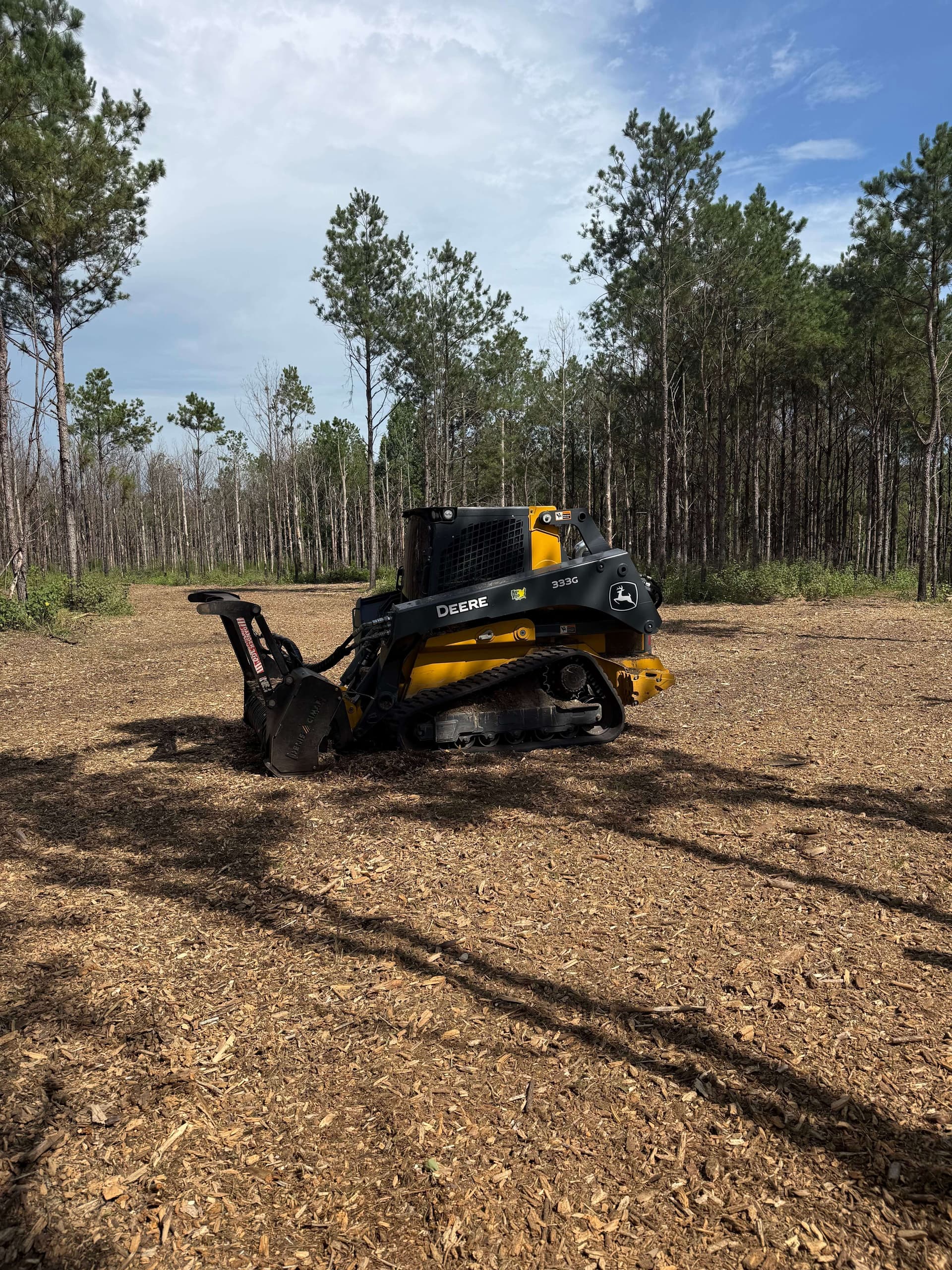 John Deere skid steer with forestry mulching head on a cleared Central Florida job site