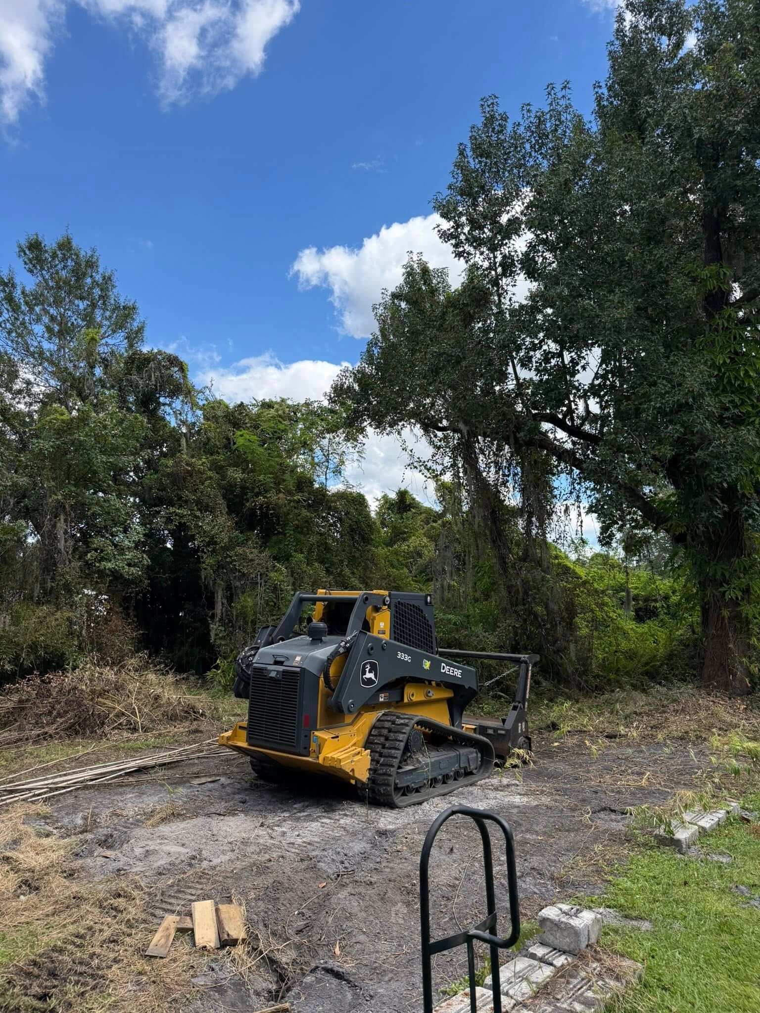 Skid steer clearing a residential wooded lot